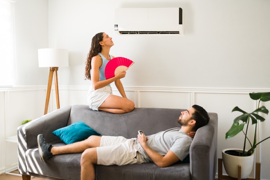 A man and woman relax on a couch with a fan in Glendora, CA